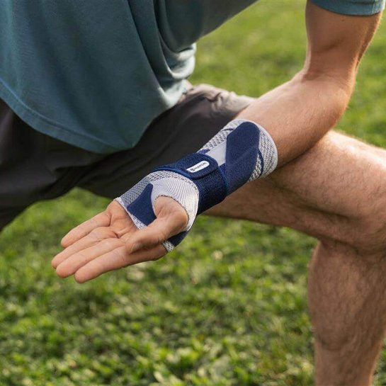Bildausschnitt eines Mannes in Yoga-Pose. Zur Unterstützung seines Handgelenks trägt er bei den Übungen eine ManuTrain Handgelenkbandage von Bauerfeind.