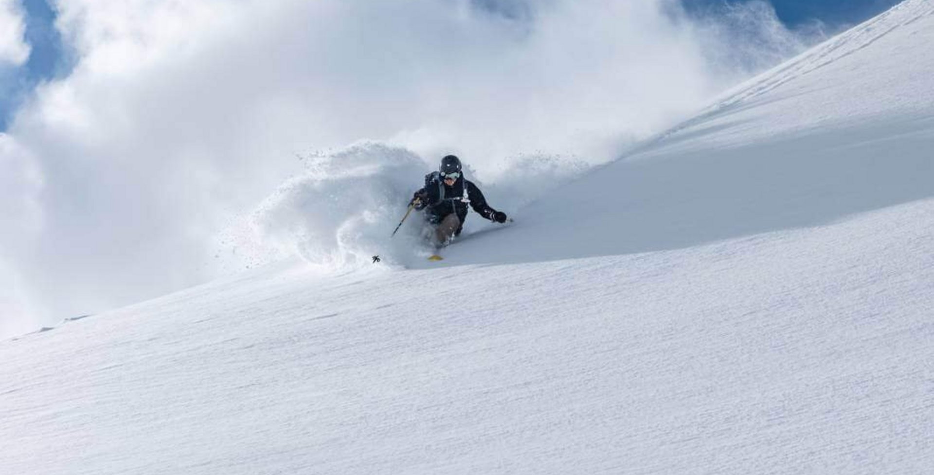 Abgebildet ist der Skifahrer Tom Klocker beim Fahren einer Kurve auf der Skipiste.