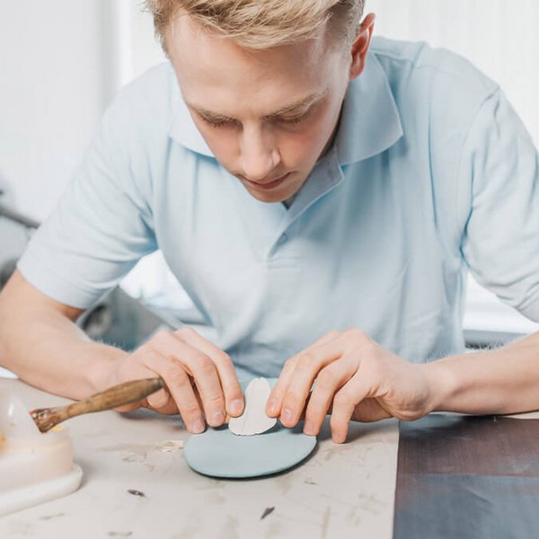 Ein junger Mann bessert eine Schuheinlage aus. Bauerfeind bietet diverse Serviceleistungen für Sanitätsfachhändler und Orthopädie(schuh)techniker.