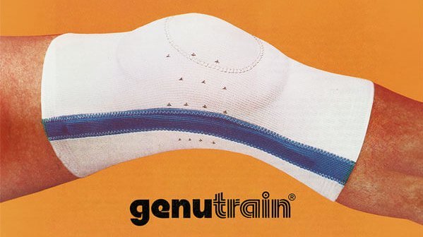 Anzeige für eine GenuTrain. Die Kniebandage mit blauen Akzenten, getragen an einem ausgestreckten Bein vor orangefarbenem Hintergrund. Unterhalb des Knies ist das Markenlogo „genutrain®“ abgebildet.